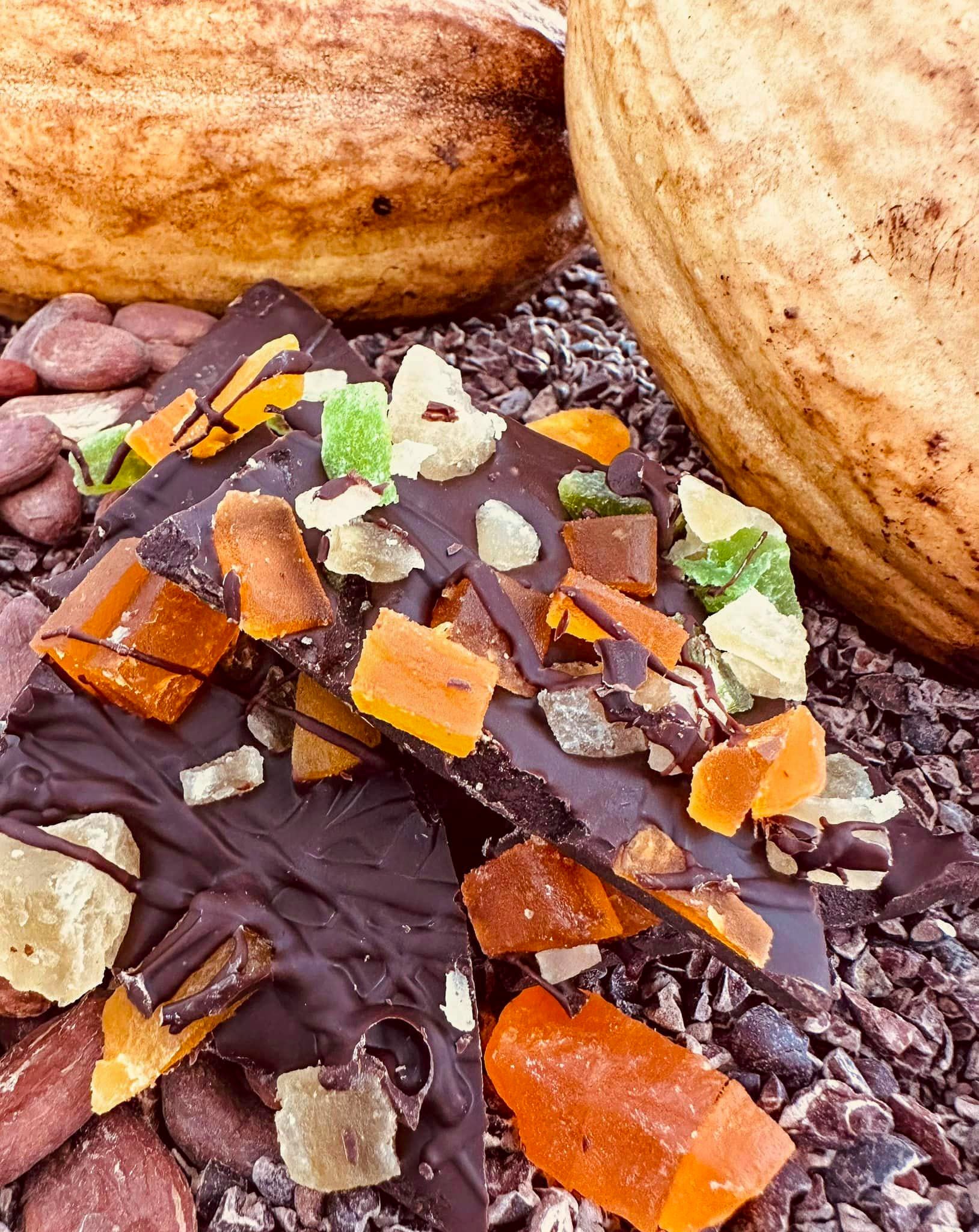 Chocolate bark with colorful dried fruit and cacao in background