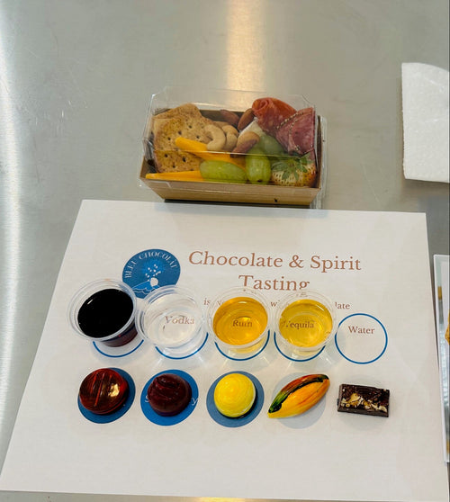 Chocolate and spirit tasting set with various samples on a branded tasting mat.