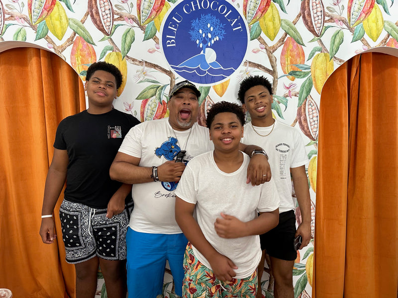 Four people posing in front of a colorful backdrop with 'Bleu Chocolat' branding.
