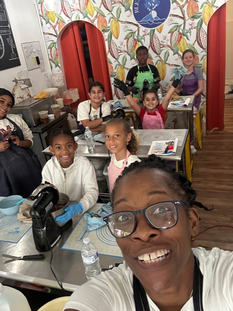 Group of children and a teacher in a classroom setting with colorful decor.