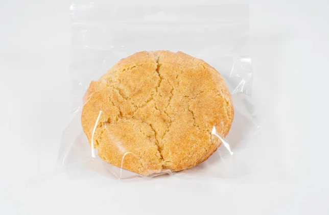 Snickerdoodle cookie wrapped in clear plastic on a white background