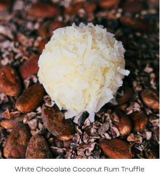 White chocolate coconut rum truffle on a bed of cacao