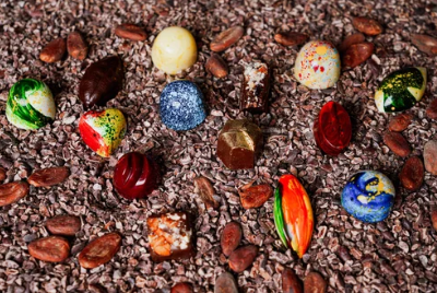 Colorful chocolate bon bons on a bed of cacao